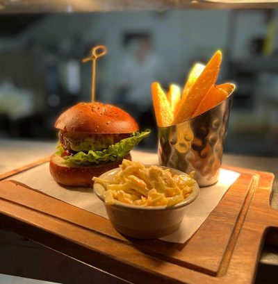 Clive’s Handmade burger, pickled cucumber, melted cheese & homemade tomato relish triple cooked chips & Slaw